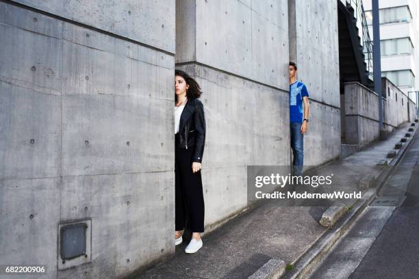 a boy and a girl showing their half bodies from the wall - narrow stockfoto's en -beelden