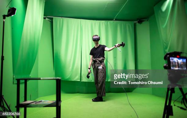 Visitor wearing an HTC Corp. Vive VR headset plays the Circle of Saviors Beginners virtual reality video game at the VR Park Tokyo on May 12, 2017 in...