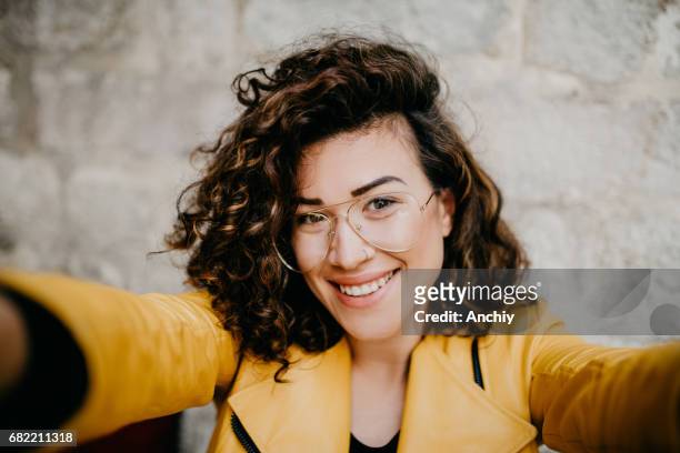 beautiful girl with glasses and nose ring is taking a selfie - hipster girl stock pictures, royalty-free photos & images