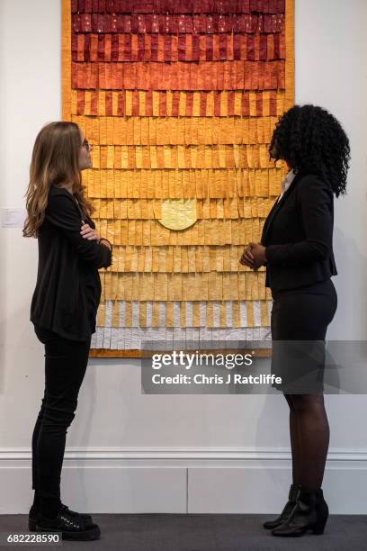 Sotheby's employees pose next to Composition No. 25 , estimated at £10,000-£15 during a press call for an inaugural sale of modern and contemporary...