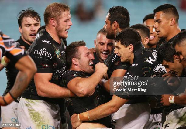 Sam Burgess of the Rabbitohs celebrates with team mates after scoring his second try during the round ten NRL match between the Wests Tigers and the...