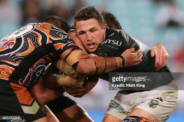 Sam Burgess of the Rabbitohs is tackled during the round ten NRL match between the Wests Tigers and the South Sydney Rabbitohs at ANZ Stadium on May...
