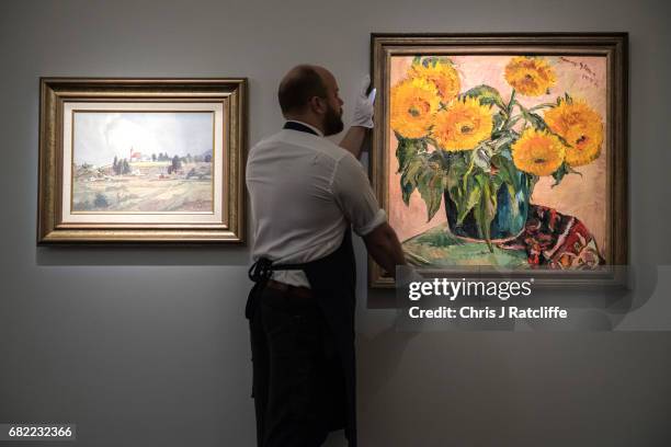 Sotheby's art handler poses with Sunflowers by Irma Stern, estimated at £350,000-£550 during a press call for an inaugural sale of modern and...