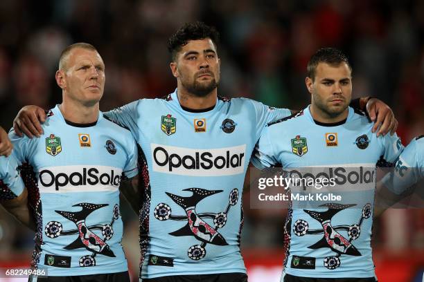 Luke Lewis, Andrew Fifita and Wade Graham of the Sharks stand for the national anthem before the round 10 NRL match between the St George Illawarra...