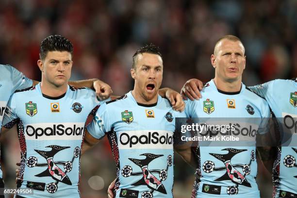 Chad Townsend, James Maloney and Luke Lewis of the Sharks stand for the national anthem before the round 10 NRL match between the St George Illawarra...