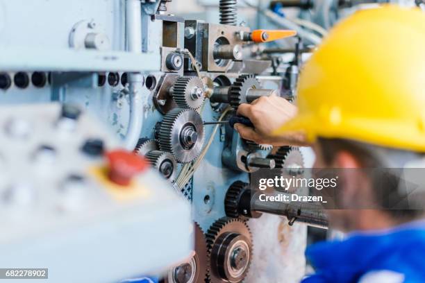 engineer fixing cog wheels, gears and machine teeth - engineer gearwheel factory stock pictures, royalty-free photos & images