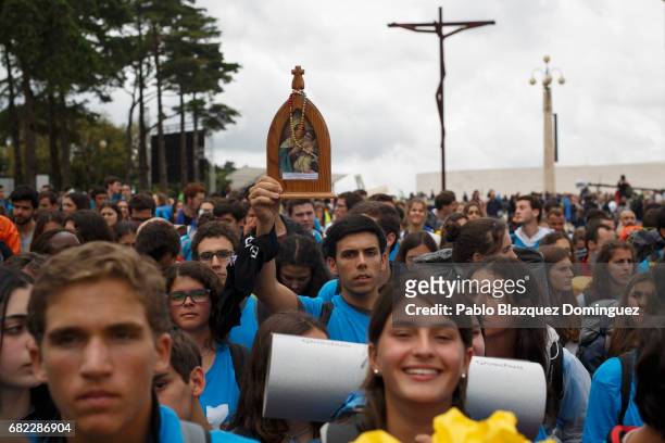 Young pilgrim holds an image of the Virgin Mary as they arrive at the Sanctuary of Fatima on May 12, 2017 in Fatima, Portugal. Pope Francis will be...