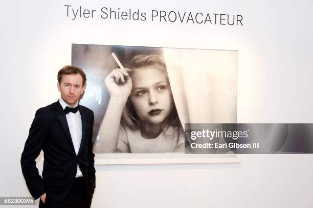 Photographer Tyler Shields poses next to one of his photos at his "Provocateur" Opening at Leica Store and Gallery Los Angeles on May 11, 2017 in Los...