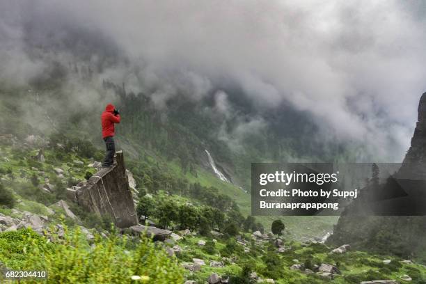 photographer in red jacket take photo of fog in rainy day on summer at mountain peak of rohtang pass,manali,himachal pradesh,india - rainy season stock pictures, royalty-free photos & images