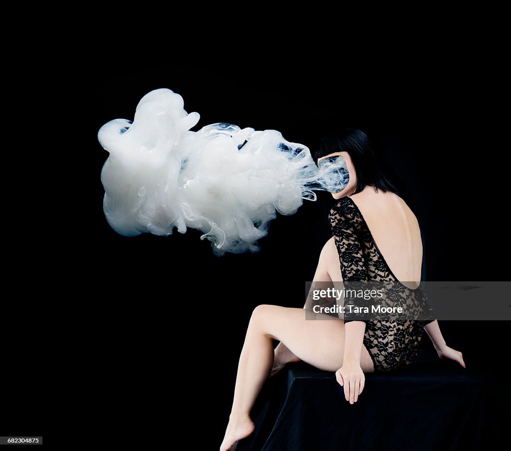 Woman with smoke coming our of face