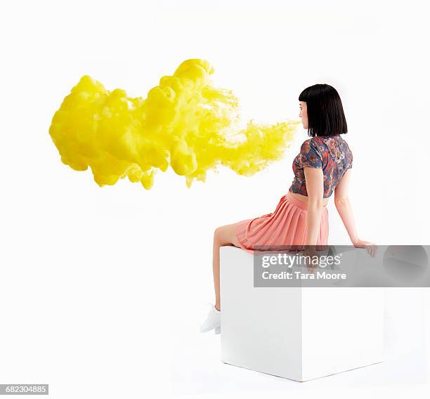 woman blowing bright yellow smoke - skirts blowing up 個照片及圖片檔