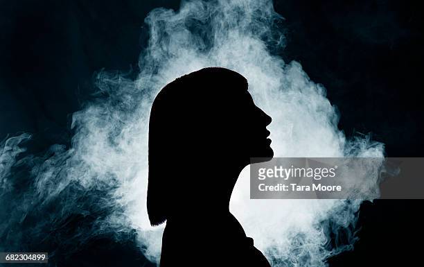 silhouette of woman with smoke - dreamlike stock pictures, royalty-free photos & images