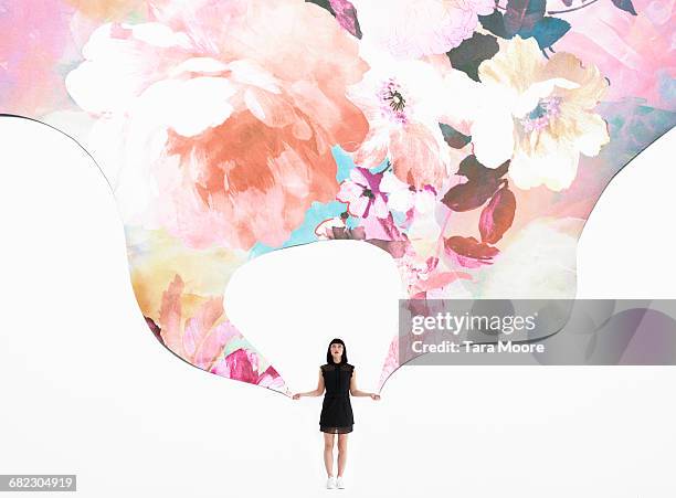 woman holding flowered wallpaper