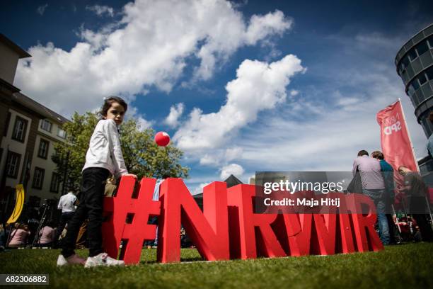 Girl stands next to SPD logo near the stage at the final SPD campaign rally in state elections in North Rhine-Westphalia on May 12, 2017 in Duisburg,...