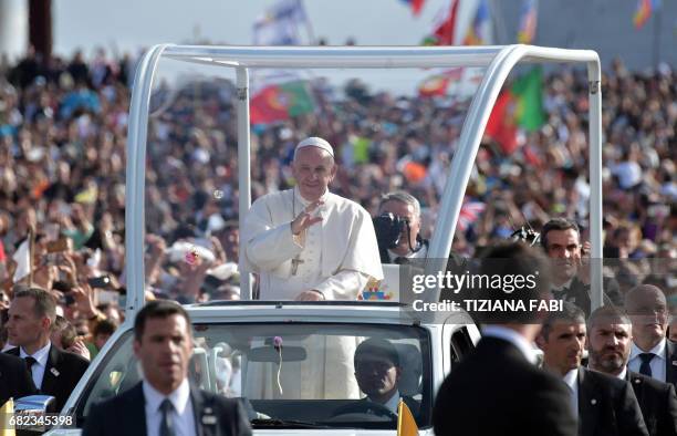 Pope Francis waves from his car upon his arrival to Fatima shrine, in Fatima, on May 12, 2017. Two of the three child shepherds who reported...