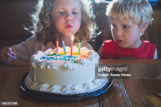 Kids Blowing Out Candles on Cake