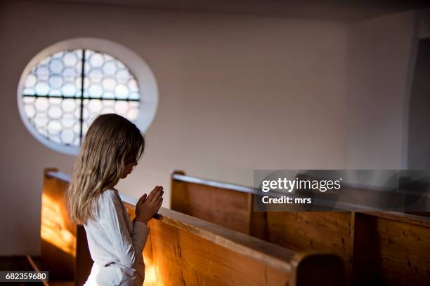 girl praying at the church - children praying stock pictures, royalty-free photos & images