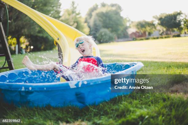 little boy sliding into kiddy pool - annie sprinkle stock pictures, royalty-free photos & images