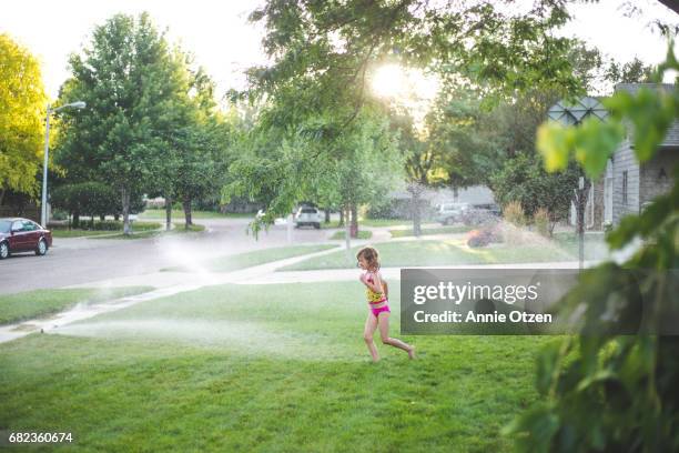 girl running through sprinkler - annie sprinkle stock pictures, royalty-free photos & images