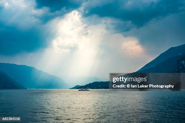 lake como with ferry and dramaric sky, como, lombardy, italy - 空気感 ストックフォトと画像