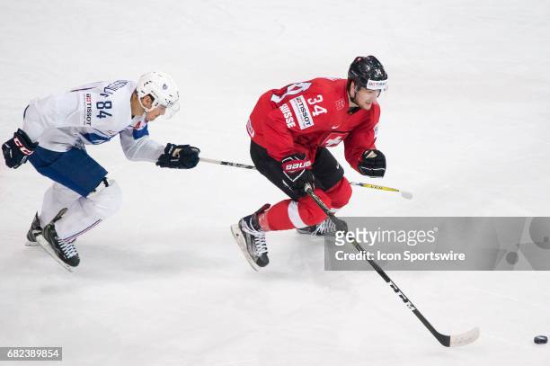 Dean Kukan vies with Kevin Hecquefeuille during the Ice Hockey World Championship between Switzerland and France at AccorHotels Arena in Paris,...