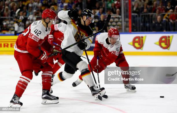 Nicholas Jensen of Denmark challenges Philip Gogulla of Germany for the puck during the 2017 IIHF Ice Hockey World Championship game between Denmark...