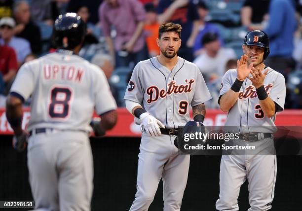 Detroit Tigers Nicholas Castellanos and Ian Kinsler waiting at home plate for teammate Justin Upton after Upton hit a three run home run in the first...