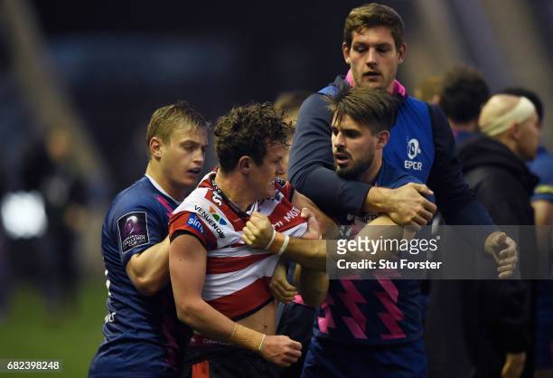 Billy Burns of Gloucester scuffles with Jules Plisson and Hugo Bonneval of Stade Francais during the European Rugby Challenge Cup Final between...