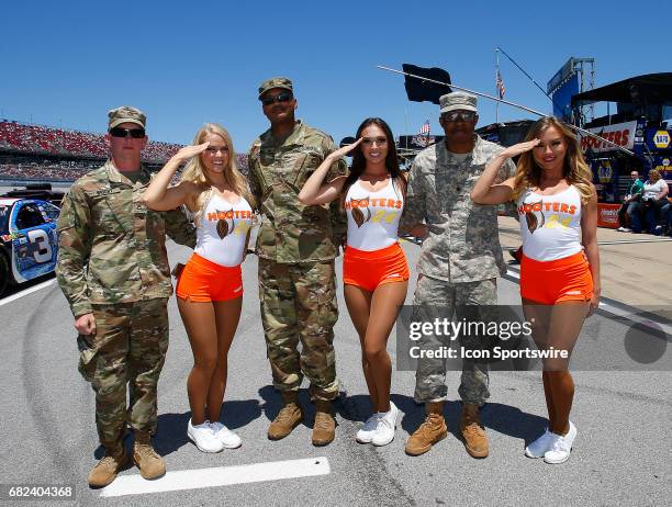 The Hooters girls pose with some U.S. Army soldiers prior to the Monster Energy NASCAR Cup Series race on May 7, 2017 at Talladega Superspeedway in...