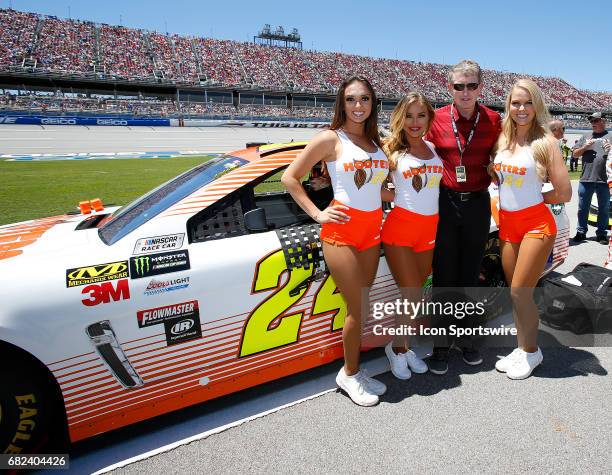 Former NASCAR Champion Bill Elliott pose next to his son's race car with the Hooters Girls prior to the Monster Energy NASCAR Cup Series race on May...