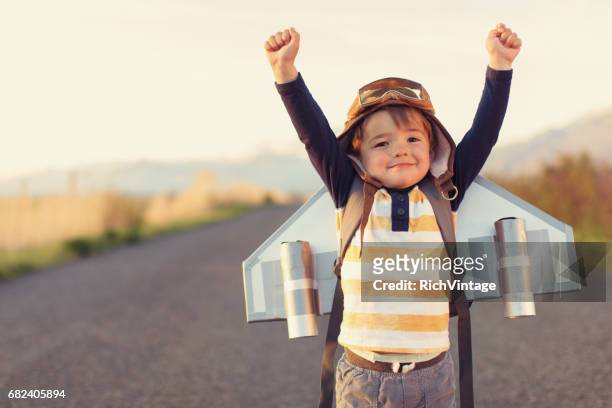 jongen met jet pack met opgeheven armen - airplane wing stockfoto's en -beelden