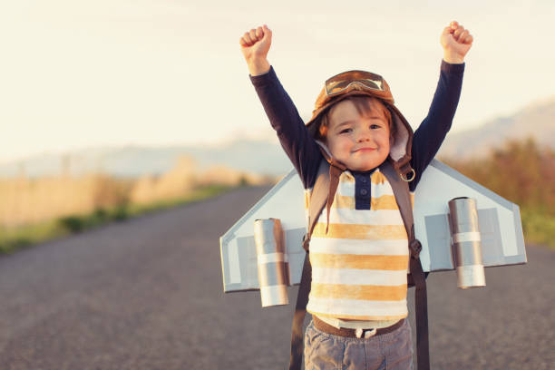 young boy with jet pack with arms raised - kids stock pictures, royalty-free photos & images