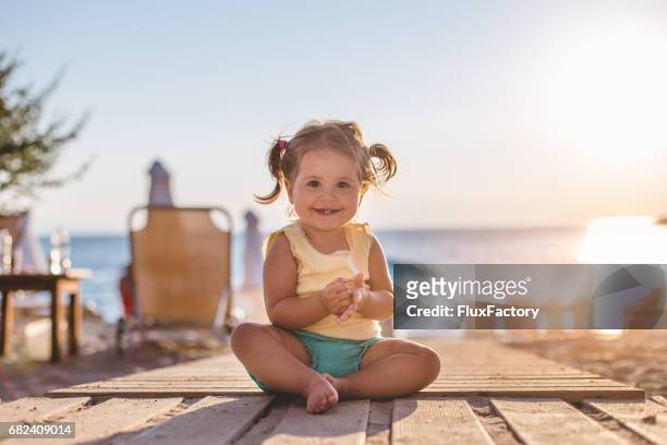 mooi meisje zit in de zon - baby sommer stockfoto's en -beelden