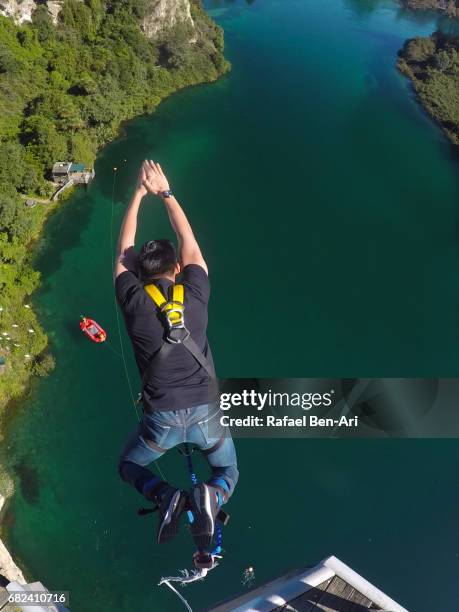 young man bungy jumps in taupo new zealand - bungee jump stockfoto's en -beelden