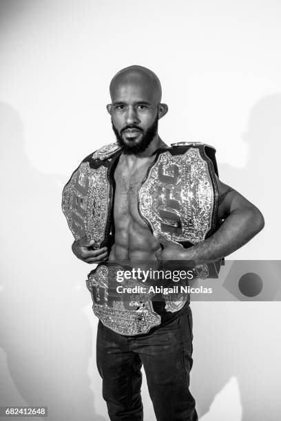 Portrait of UFC Flyweight champion Demetrious Johnson posing with belts during photo shoot at Time Inc. Studios. Johnson has succesfully defended his...