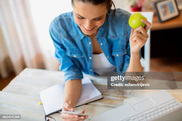 wokring at home and eating green apple - wokring out stock pictures, royalty-free photos & images