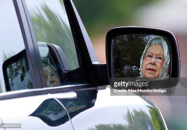 Queen Elizabeth II seen reflected in the wind mirror of her Range Rover car as she drives around the Royal Windsor Horse Show in Home Park on May 12,...