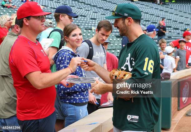 Adam Rosales of the Oakland Athletics signs autographs with the fan before the game against the Texas Rangers at Globe Life Park in Arlington on May...