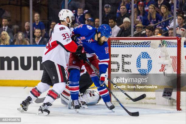 Ottawa Senators defenseman Fredrik Claesson checks New York Rangers left wing Tanner Glass in front of the net during the first period of game 6 of...
