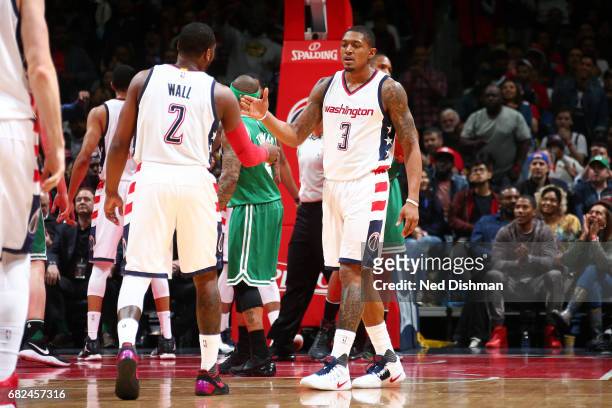 Bradley Beal and John Wall of the Washington Wizards high five each other during the game against the Boston Celtics during Game Six of the Eastern...