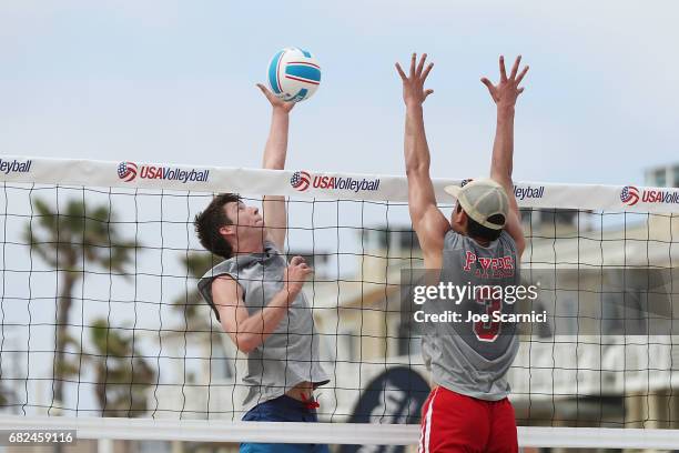 Michael Saeta of UC Irvine spikes over Matthew Yoshimoto of Lewis University during the quarter final match at the 2017 USA Volleyball Collegiate...