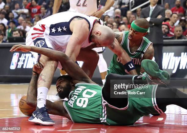 Marcin Gortat of the Washington Wizards scrambles for a loose ball against Amir Johnson and Isaiah Thomas of the Boston Celtics during Game Six of...