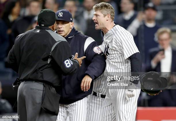 Manager Joe Girardi of the New York Yankees tries to separate home plate umpire Adrian Johnson and Chase Headley in the seventh inning against the...