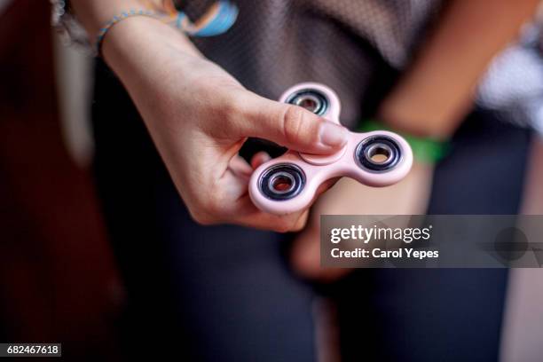 spinner.teen girl playing with toy - distracted 個照片及圖片檔