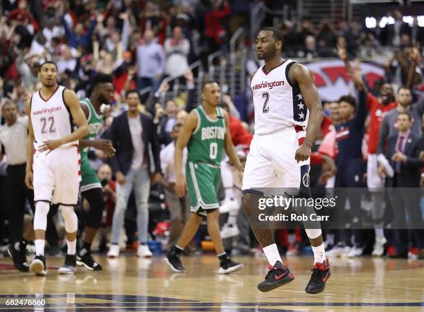 John Wall of the Washington Wizards reacts after hitting the game-winning three-point basket against Avery Bradley of the Boston Celtics during Game...