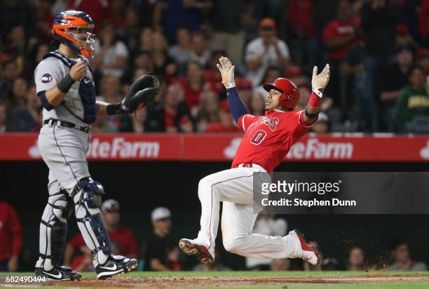 Yunel Escobar of the Los Angeles Angels of Anaheim slides home with a run in the sixth inning past catcher Alex Avila of the Detroit Tigers at Angel...