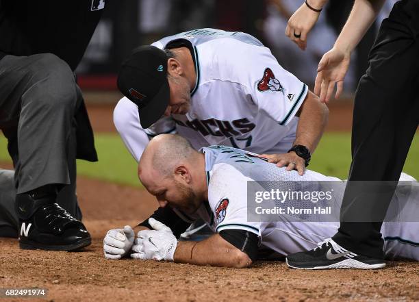 Chris Iannetta of the Arizona Diamondbacks is looked at by manager Torey Lovullo after getting hit in the face with a pitch by Johnny Barbato of the...