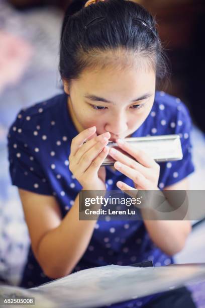 teenager playing harmonica - leren 個照片及圖片檔