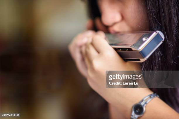 teenager playing harmonica - harmonica stock-fotos und bilder