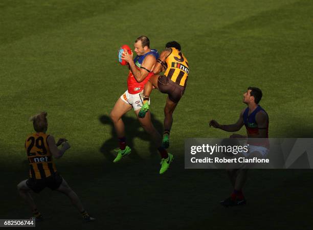 Josh Walker of the Lions is challenged by Cyril Rioli of the Hawks during the round eight AFL match between the Hawthorn Hawks and the Brisbane Lions...